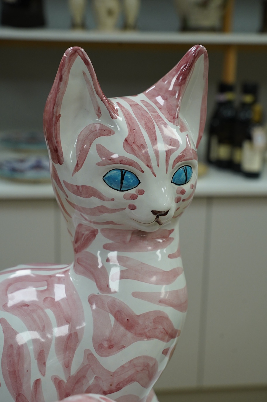 A large 1950's Italian pink maiolica seated cat and two smaller, largest 45cm. Condition - poor